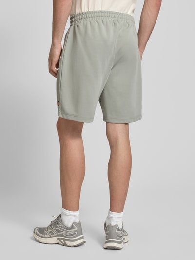 Männermodel trägt Shorts mit Label-Stitchings Modell 'BERTONI' von ellesse, Relaxed Fit, Baumwoll-Mix, Ganzkörperansicht Rückansicht.