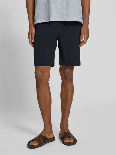 Mężczyznamodel nosi Shorts mit elastischem Bund Modell 'Samos' od Casual Friday, ciemnogranatowy, krój regular fit, materiał z wiskozą, szerokość w rozmiarze M: 40 cm, długość wewnętrzna nogawki 21 cm, ujęcie całej sylwetki z przodu.