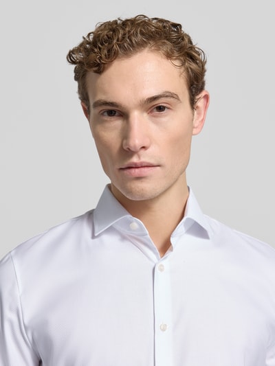 Männermodel trägt Super Slim Fit Business-Hemd mit Kentkragen von OLYMP No. Six aus Baumwoll-Elasthan-Mix, Nahaufnahme Oberkörper.