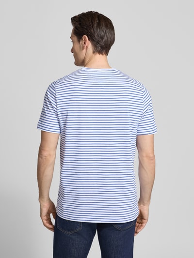 Männermodel trägt Regular Fit T-Shirt aus reiner Baumwolle von Tommy Hilfiger, Optik:Allover-Muster, gestreift, Ganzkörperansicht Rückansicht.