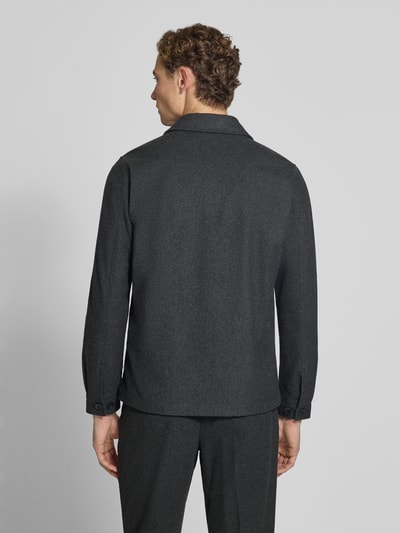 Męski model nosi Regular Fit Jacke mit Woll-Anteil von Lindbergh, elastyczna mieszanka materiałów z dodatkiem wełny, wykładany kołnierz, Brustasza, listwa guzikowa, kolor ciemnoszary, długość tyłu w rozmiarze M: 72 cm, widok całej sylwetki od tyłu.