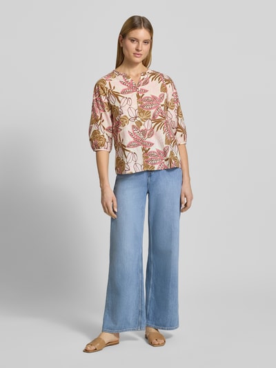 Frauenmodel trägt Regular Fit Bluse mit floralem Allover-Print von Soyaconcept aus reiner Baumwolle, Tunika-Ausschnitt, Knopfleiste, Ganzkörperansicht von vorne.
