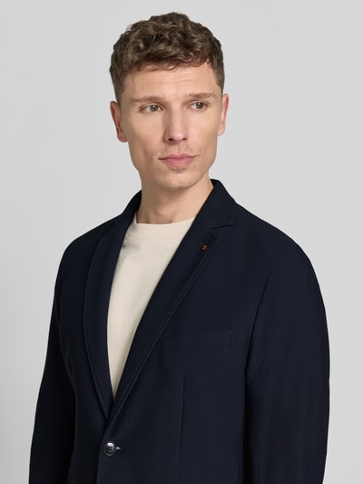 Männermodel trägt Slim Fit 2-Knopen-sakko met structuurpatroon model 'Bob' van Zuitable, blauw, materiaal-mix met stretch, reverskraag, opgestikte zakken, bovenlichaam dichtbij, voorkant.