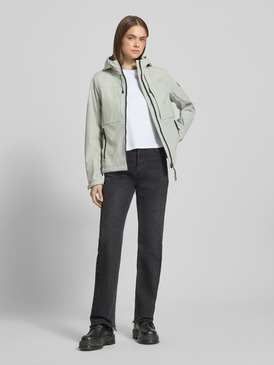Frauenmodel trägt Trekker Jacke mit Kapuze und Label-Patch von Superdry in hellem Grau, Material-Mix mit Stretch, gerader Schnitt, Ganzkörperansicht von vorne.