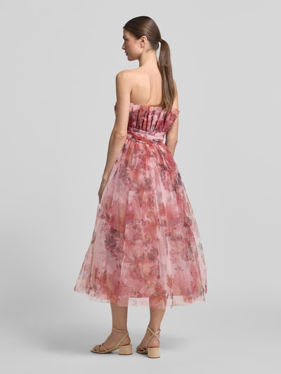 Vrouwenmodel draagt Regular Fit midi-jurk met bloemen all-over print van Lace & Beads, mesh, getailleerd, A-lijn, ruglengte maat S 104 cm, borstwijdte maat S 35 cm, plooien en plooidetails, strapless design, roze tinten, geheel van achteren.