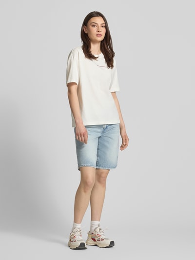 Frauenmodel trägt Regular Fit T-Shirt aus reiner Baumwolle von Marc O'Polo Denim in Unifarbe mit Motiv-Print, Rundhals, kurzarm, Jerseystruktur, Ganzkörperansicht von vorne.