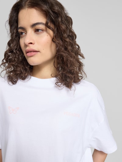 Frauenmodel trägt Oversized T-Shirt mit Motiv- und Logo-Print Modell 'NIVELLES' von Pegador, reine Baumwolle, Nahaufnahme Oberkörper.