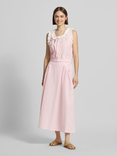 Frauenmodel trägt Cropped Blusentop mit Rüschen Modell 'Sona' von OH APRIL aus reiner Baumwolle, rosa-weiß kariert, Ganzkörperansicht von vorne.