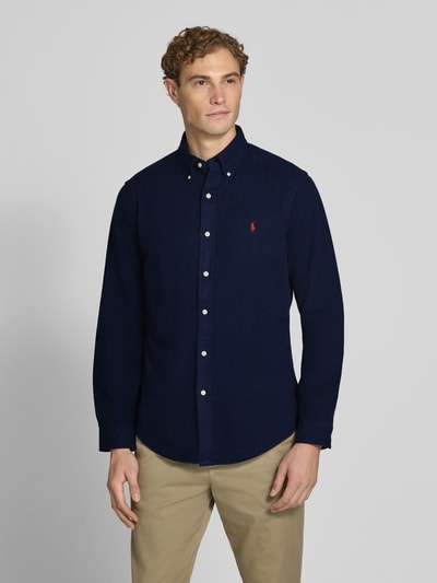 Męski model ma na sobie granatową koszulę casualową Custom Fit Freizeithemd aus reiner Baumwolle von Polo Ralph Lauren, gładka faktura, kontrastowe guziki, Ganzkörperansicht von vorne.