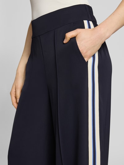 Frauenmodel trägt Stoffhose mit elastischem Bund von Comma, dunkelblauer Material-Mix mit Stretch-Anteil, Ziernähte, Nahaufnahme Oberkörper.