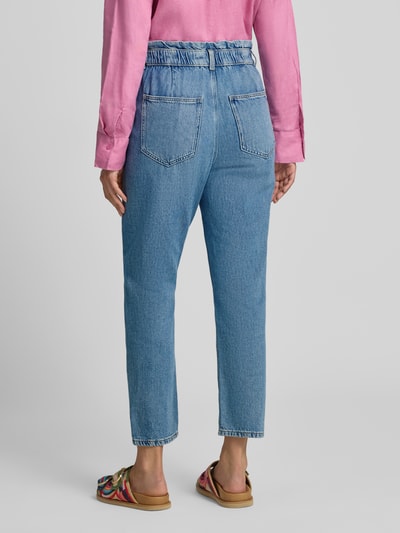 Frauenmodel trägt Tapered Fit Jeans aus reiner Baumwolle von Jake*s Casual in hellem Blau mit sichtbarer Struktur, Ganzkörperansicht Rückansicht.