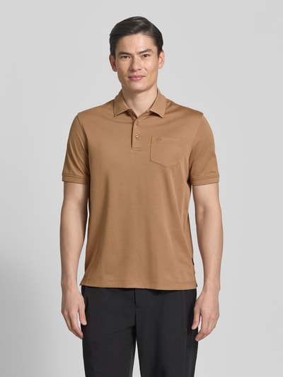 Männermodel trägt Regular Fit Poloshirt mit Brusttasche und Label-Stitching von bugatti, braun, Polokragen, Knopfleiste, Ganzkörperansicht von vorne. Rückenlänge bei Größe M: 70 cm.