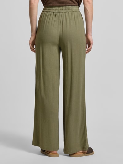 Männermodel trägt Regular Fit Weite Hose aus Viskose-Leinen-Mix Modell 'VIVA-GULIA' von Selected Femme, efekt: jednolity kolor, krój regular fit, tunel, elastyczny ściągacz, wpuszczane kieszenie, wykończenie materiału: cieniowana przędza, materiał: mieszanka wiskozy i lnu, Ganzkörperansicht Rückansicht.