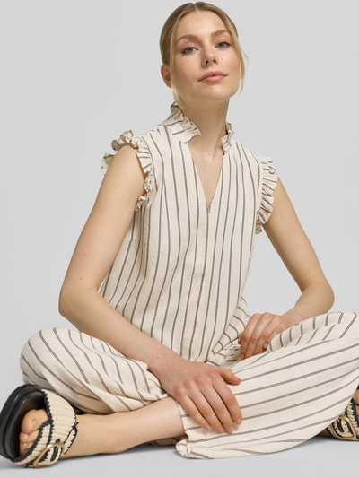 Modelka kobieca nosi Regular Fit Top mit Leinen-Anteil Modell 'VIVA' od Selected Femme, kremowe paski, wzór allover, rzędy falban, materiał mieszanka wiskozy i lnu, krój regular fit, dekolt w serek, zdjęcie całego ciała z przodu.