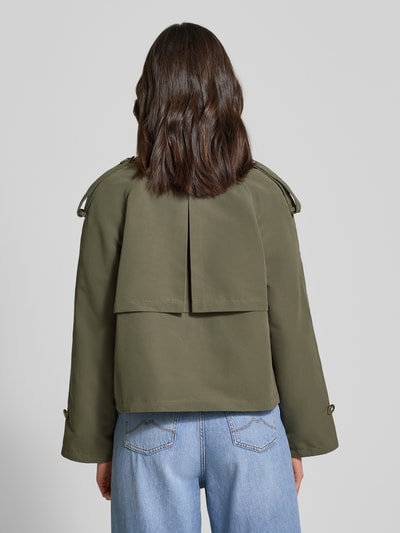 Frauenmodel trägt Boxy Fit Trenchcoat mit doppelreihiger Knopfleiste Modell 'CHLOE' von Vero Moda in Olivgrün, unifarben, Ganzkörperansicht Rückansicht