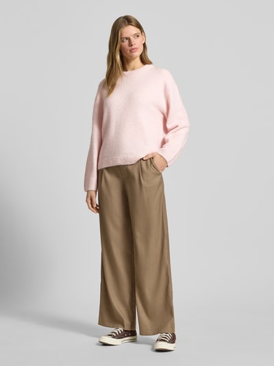 Vrouwenmodel draagt gebreide pullover met wol van Gina Tricot, materiaalmix, los model, ribboorden, ronde hals, ruglengte 59 cm, mouwlengte 66 cm. Ganzkörperansicht von voren.