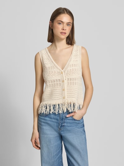 Frauenmodel trägt Regular Fit Weste aus Baumwoll-Mix Modell 'ALIX' von Only in Strickoptik mit Fransen und Strukturmuster, Nahaufnahme Oberkörper.