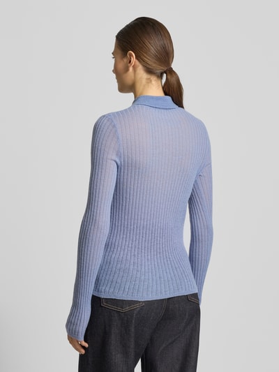 Vrouwenmodel draagt Slim Fit gebreide pullover uit scheerwolmix model 'FUGENEL' van BOSS Orange, effen en gestreepte look, polokraag, labelstitching, lange mouw, geribde mouw- en rompzoom, mix van scheerwol, gebreide textuur. Ganzebody van achteren.