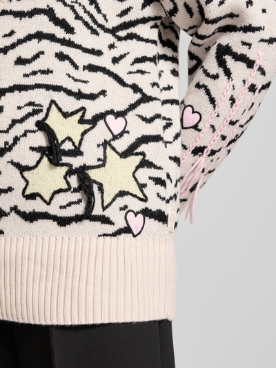 Frauenmodel trägt Strickjacke mit Knopfleiste von Marc Cain, Reine Baumwolle, Lockerer-Schnitt, Gerippte-Abschlüsse, V-Ausschnitt, Rosa, Schwarz, gemustert mit Stern- und Herzdetails, Rückenlänge 68 cm, Ärmellänge 56 cm, Nahaufnahme Oberkörper.