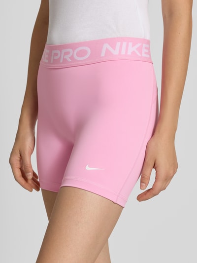 Mädchen trägt Skinny Fit Sportshorts mit elastischem Label-Bund von Nike, Damen Sportshorts von Nike, Nahaufnahme Oberkörper
