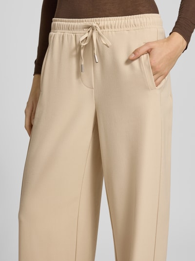 Vrouwenmodel draagt Hose met elastische band model 'Melane flow' van OPUS, regular fit, materiaalmix met viscose, beige. Detailopname voorzijde.