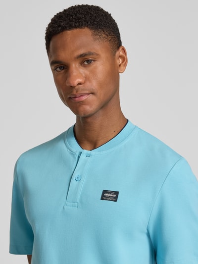 Männermodel trägt Regular Fit Poloshirt aus Baumwoll-Mix von s.Oliver RED LABEL, Optik: Unifarben, Label-Patch, Nahaufnahme Oberkörper.
