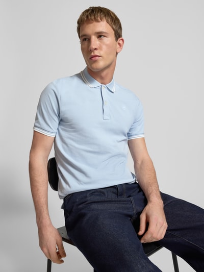 Männermodel trägt Slim Fit Poloshirt mit Logo-Stitching Modell 'Dunda' von G-Star Raw aus elastischem Baumwoll-Mix in Hellblau, Nahaufnahme Oberkörper.