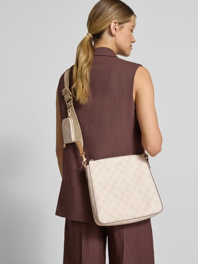 Frauenmodel trägt Handtasche mit Schulterriemen Modell 'jasmina' von JOOP! in Beige mit Label-Applikation, Hauptfach mit Reißverschluss, abnehmbarer und verstellbarer Schulterriemen, Maße 26 cm x 26 cm x 6 cm, Riemenlänge 106 cm, Ganzkörperansicht Rückansicht.