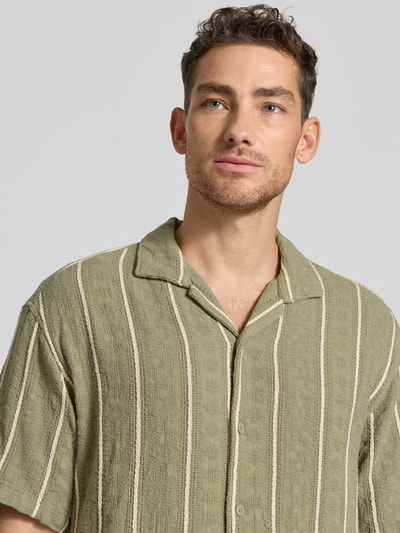 Männermodel trägt Regular Fit Freizeithemd mit Streifenmuster von MCNEAL aus reiner Bio-Baumwolle, Reverskragen, Knopfleiste, Nahaufnahme Oberkörper.