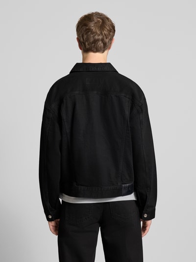 Mężczyzna nosi Jeansjacke mit Brusttaschen und Label-Detail von Calvin Klein Jeans, czarna bawełna, krój regular fit, widok całej sylwetki z tyłu