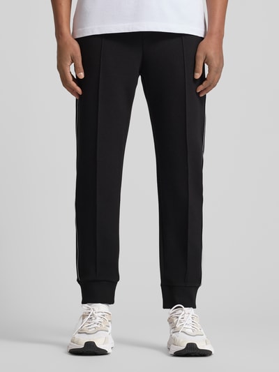 Männermodel trägt Regular Fit Sweatpants aus Baumwoll-Mix Modell 'JOIN HADIKO' von BOSS Green, Optik: Unifarben, Ganzkörperansicht von vorne.