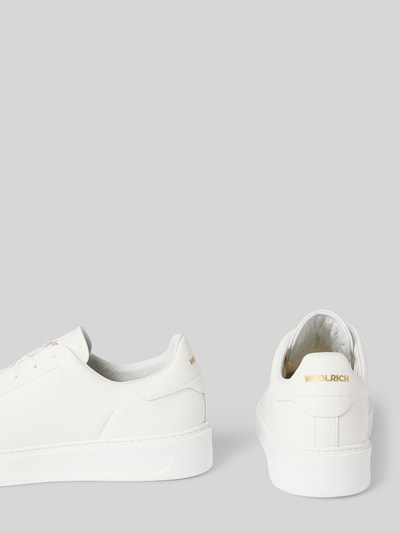 Produktfoto, Sneaker aus echtem Leder Modell 'CLASSIC COURT' von Woolrich in Weiß mit abgerundeter Form, strukturierter Sohle, Label-Print
