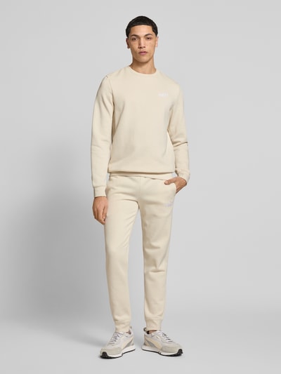 Männermodel trägt Regular Fit Sweatshirt mit Logo-Stitching von PUMA PERFORMANCE, Baumwoll-Mix, Rundhalsausschnitt, Beige, Ganzkörperansicht von vorne.
