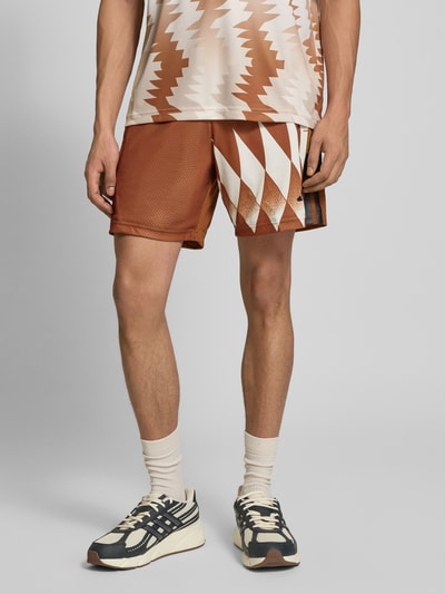 Mannenmodel draagt Regular Fit Sweatshorts met all-over motief van adidas Sportswear, elastische boord, zij-steekzakken, labelprint; vooraanzicht, detailopname benen.