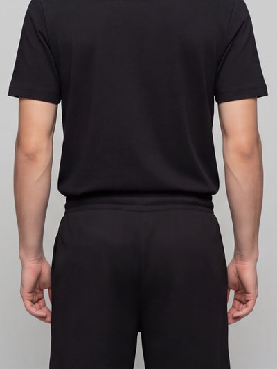 Männermodel trägt Relaxed Fit Sweatshorts aus mieszanka bawełny 'ESS ELEVATED' von PUMA, Herren Sweatshorts, Ganzkörperansicht Rückansicht
