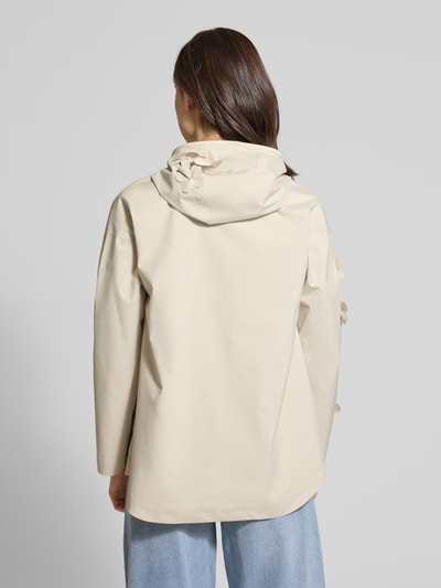 Frauenmodel trägt Regular Fit Regenjacke mit floralen Applikationen Modell 'Rosa' von SAVE THE DUCK in Beige, Rückansicht, glatte Textur, Kapuze, Reißverschluss, Logo-Patch, Rückenlänge 72 cm, Schulterbreite 57 cm, Brustweite 45 cm, Ärmellänge 50 cm. Ganzkörperansicht Rückansicht.