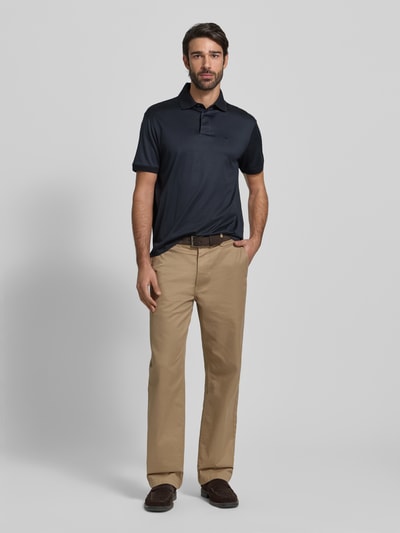 Männermodel trägt Poloshirt mit kurzer Knopfleiste von Emporio Armani im Lyocell-Baumwolle-Mix, Regular-Fit, Polokragen, Label-Stitching, gerippte Ärmelabschlüsse, Rückenlänge bei Größe M 70 cm, dunkelblau, glatte Textur, Ganzkörperansicht von vorne.