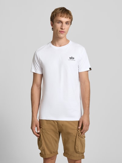Männermodel trägt T-Shirt mit Logo und Rundhalsausschnitt van Alpha Industries, witte katoen, regular fit, logoprint, vooraanzicht, halftotaal.