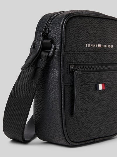 Produktfoto, Crossbody Bag met labelprint van Tommy Hilfiger, heren, zwart leerlook materiaal, verstelbare schouderband, ritssluitingen, hoofd-, binnen- en zijvak, breedte 16 cm, lengte 22 cm, diepte 8 cm, bandlengte 90 cm.