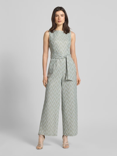 Frauenmodel trägt Regular Fit Jumpsuit mit geometrischem Allover-Stitching von Betty Barclay in Grau mit Stoffband, Ärmelloses-Design, U-Boot-Ausschnitt, Ganzkörperansicht von vorne. Rückenlänge 141 cm, Brustweite 32 cm, Innenbeinlänge 73 cm, taillierte Passform.