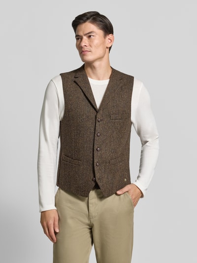 Männermodel trägt Weste mit Brustleistentasche Modell 'Warner' von Carl Gross aus reiner Wolle, erdige Farbtöne, Regular Fit, Ganzkörperansicht von vorne.