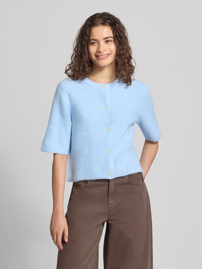 Frauenmodel trägt Boxy Fit Strickjacke aus Rippstrick Modell 'SILLY' von PIECES in Hellblau, Material-Mix mit Woll-Anteil, Ganzkörperansicht von vorne.