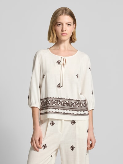 Frauenmodel trägt Bluse aus Viskose-Mix mit 3/4-Arm von Christian Berg Woman Selection, mit Schlüsselloch-Ausschnitt, Straight Fit, cremefarben, Ethno-Muster, Ganzkörperansicht von vorne.