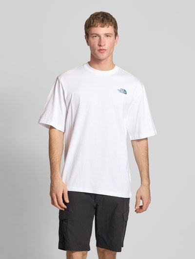 Männermodel trägt Oversized T-Shirt mit Logo und Rundhalsausschnitt von The North Face in Weiß, reine Baumwolle, Ganzkörperansicht von vorne.