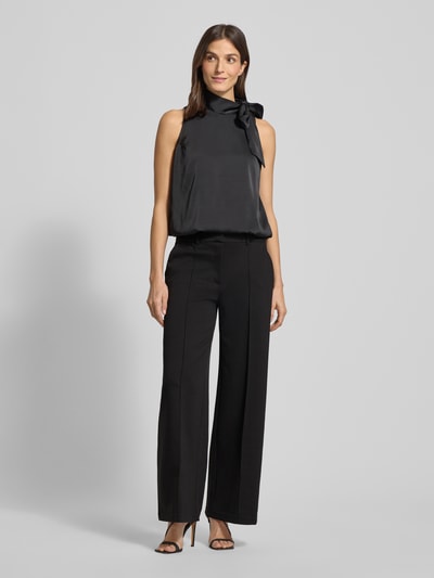 Frauenmodel trägt Wide Leg Stoffhose mit fixierten Bügelfalten Modell 'KATE' von ICHI, Material-Mix mit Viskose-Anteil, Paspeltaschen am Gesäß, Ganzkörperansicht von vorne.