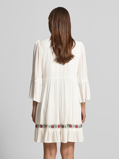 Frauenmodel trägt Tunika-Kleid mit Stitchings Modell 'CHELLA' von YAS in A-Linie als Minikleid mit Schnürung, Rückenlänge 36 cm, Brustweite 50 cm, Ärmellänge 51 cm, Ganzkörperansicht Rückansicht.