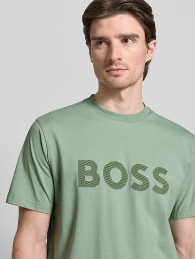 Männermodel trägt Regular Fit T-Shirt aus Baumwoll-Mix Modell 'ICONIC' von BOSS Green, unifarben, Label-Prägung, Nahaufnahme Oberkörper.
