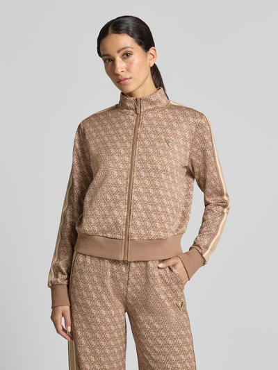 Frauenmodel trägt Regular Fit Sweatjacke mit Allover-Logo-Print von GUESS in Beige mit elastischem Material-Mix, Nahaufnahme Oberkörper.
