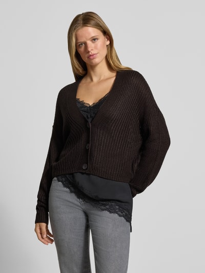 Vrouwenmodel draagt boxy fit gebreid jack met v-hals model 'CAROL' van ONLY in donkerbruin, Dames gebreid jack, grijze jeans, Ganzlichaamsaanzicht van voren