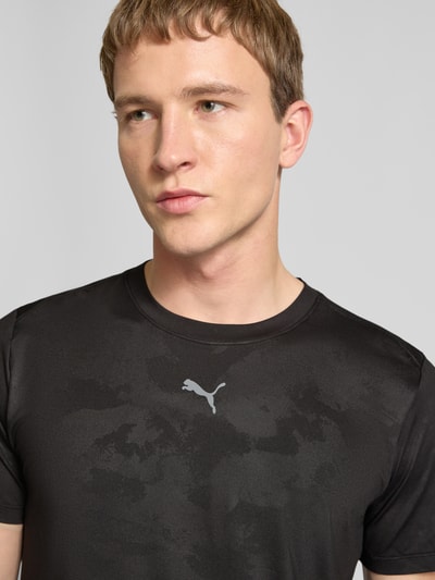 Männermodel trägt schwarzes Herren T-Shirt mit Label-Detail Modell 'CLOUDSPUN' von PUMA PERFORMANCE, Elastischer-Material-Mix, Nahaufnahme Oberkörper.